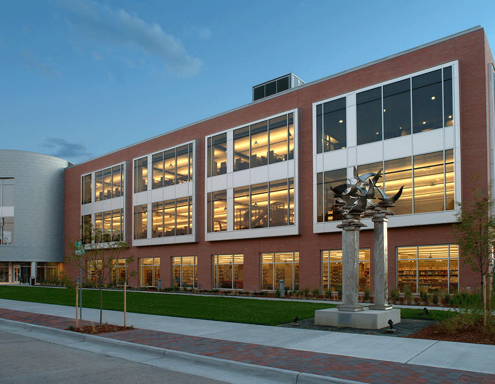 Laramie County Library in Cheyenne at dusk, with a darkening sky and the building softly lit from within.